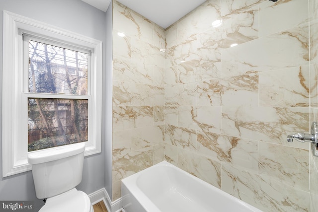 bathroom featuring toilet, tiled shower / bath combo, and a healthy amount of sunlight