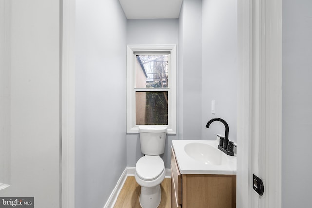 bathroom with toilet, vanity, and hardwood / wood-style flooring