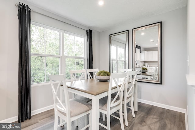 dining area with wood-type flooring, a textured ceiling, and a wealth of natural light