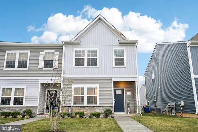 view of front of property with central AC unit and a front yard