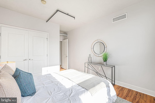 bedroom with wood-type flooring and a closet