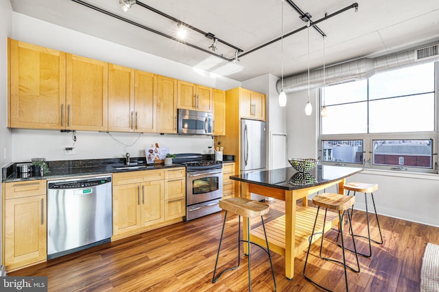 kitchen featuring light brown cabinetry, dark hardwood / wood-style flooring, and appliances with stainless steel finishes