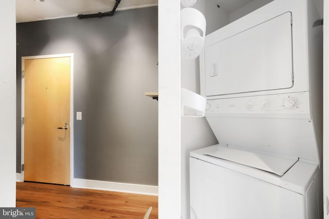 clothes washing area with stacked washer / dryer and hardwood / wood-style floors