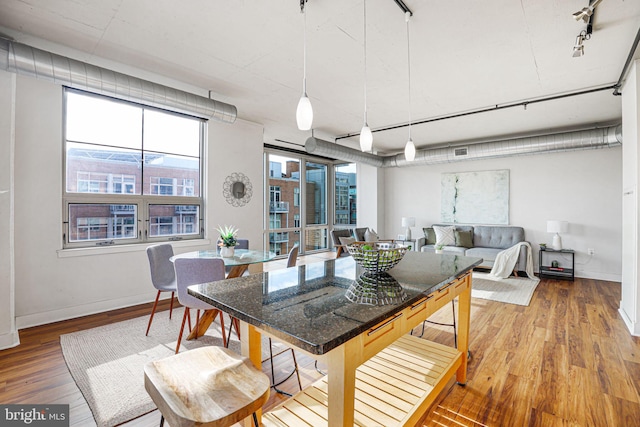 dining space featuring hardwood / wood-style flooring and rail lighting