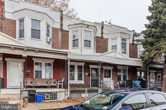 townhome / multi-family property featuring a porch and cooling unit