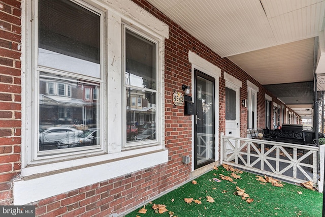 view of exterior entry featuring covered porch