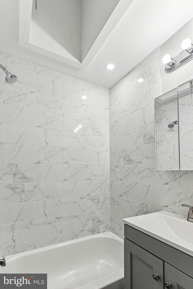 bathroom featuring vanity and tiled shower / bath