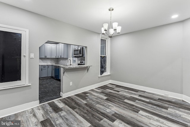 interior space with dark hardwood / wood-style flooring, a notable chandelier, and sink