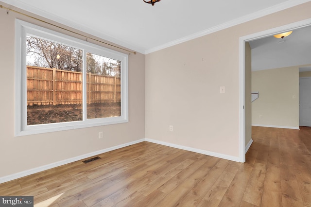 spare room with light wood-type flooring and crown molding