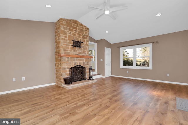 unfurnished living room featuring a fireplace, ceiling fan, light hardwood / wood-style flooring, and vaulted ceiling