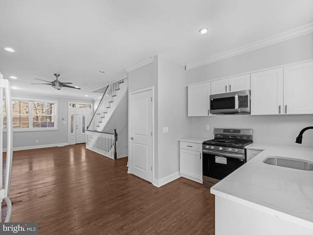 kitchen featuring appliances with stainless steel finishes, crown molding, dark wood-type flooring, sink, and white cabinetry