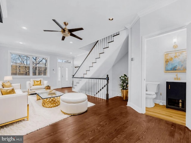 living room featuring crown molding, sink, ceiling fan, and wood-type flooring