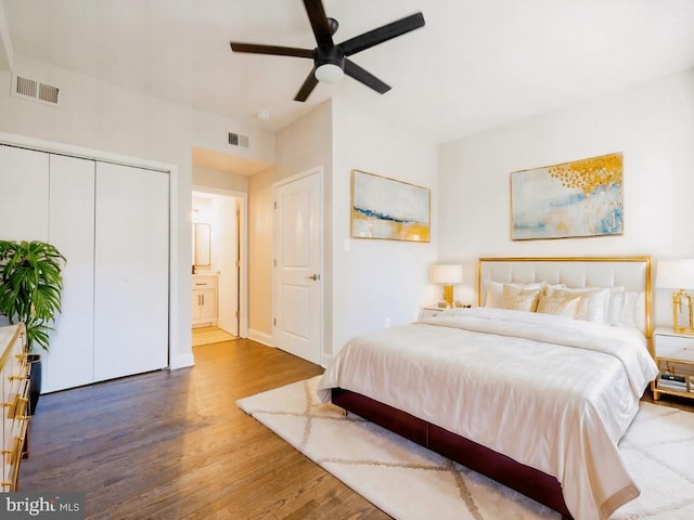 bedroom with hardwood / wood-style flooring, ceiling fan, and connected bathroom