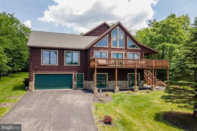 log home with a wooden deck, a front yard, and a garage