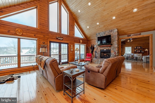 living room featuring french doors, wooden ceiling, high vaulted ceiling, light hardwood / wood-style floors, and a fireplace