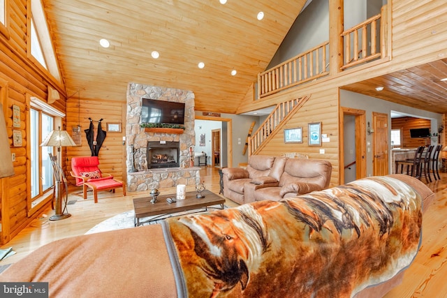 living room with light wood-type flooring, wooden ceiling, a fireplace, and high vaulted ceiling