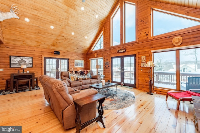 living room featuring high vaulted ceiling, french doors, wooden walls, light hardwood / wood-style floors, and wood ceiling