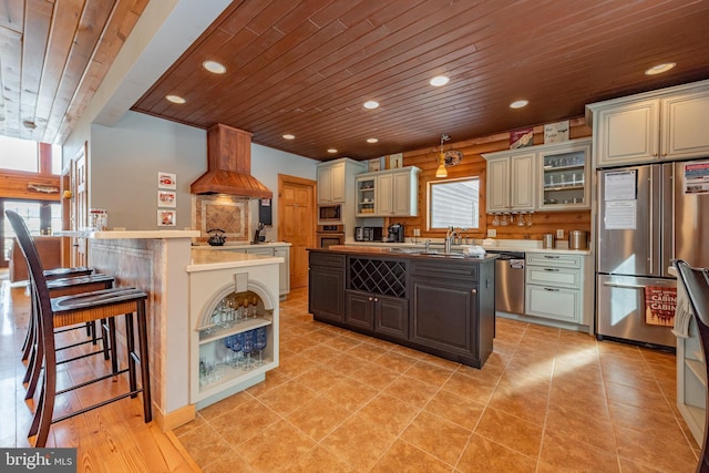 kitchen with a kitchen island, wood ceiling, and custom exhaust hood