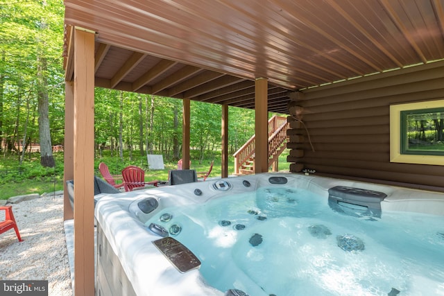 view of patio with stairway and a hot tub