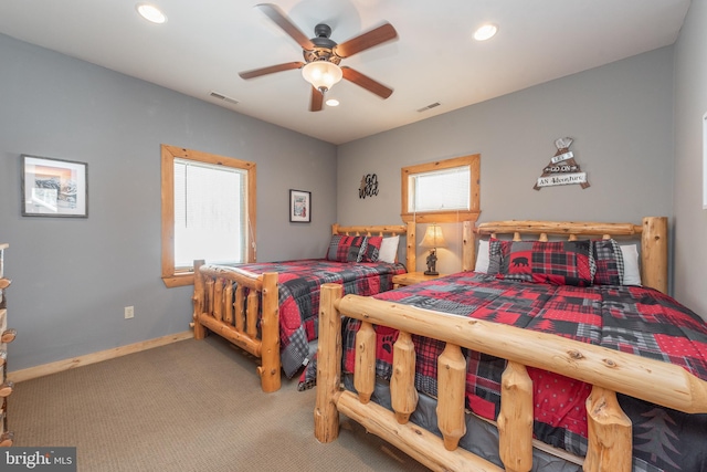 bedroom with ceiling fan, carpet floors, and multiple windows