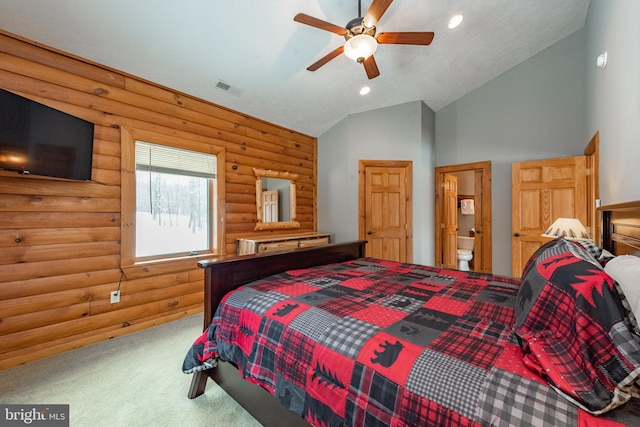 bedroom with lofted ceiling, ensuite bath, carpet flooring, ceiling fan, and rustic walls