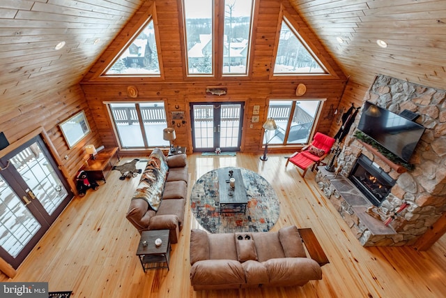 living room featuring high vaulted ceiling, french doors, wood-type flooring, a fireplace, and wood ceiling