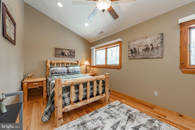 bedroom featuring hardwood / wood-style flooring, multiple windows, lofted ceiling, and ceiling fan