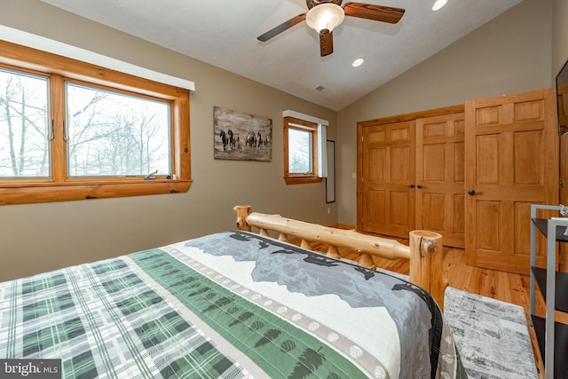 bedroom with hardwood / wood-style floors, a closet, vaulted ceiling, and ceiling fan