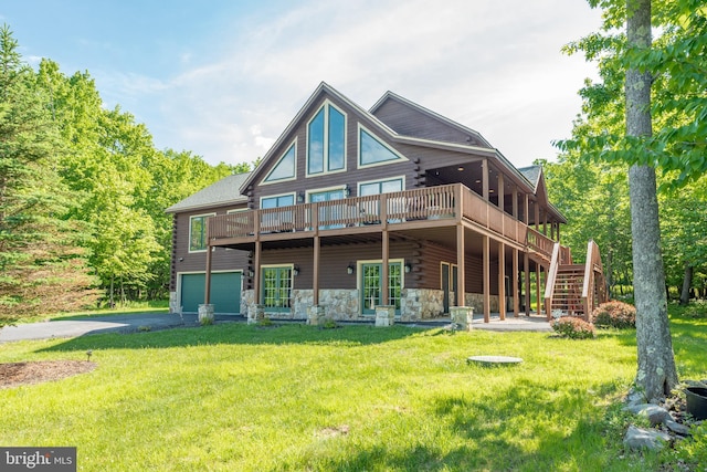 back of property with a yard, a deck, and a garage