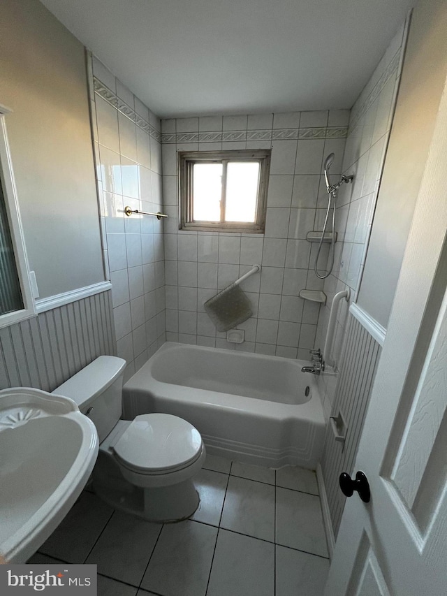 full bathroom with sink, tile patterned flooring, tiled shower / bath, and toilet