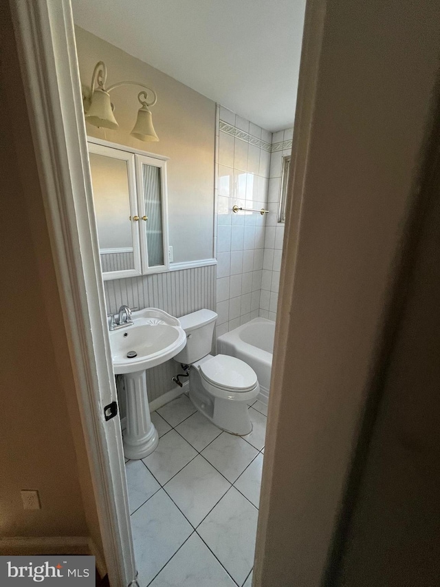 bathroom with tile patterned flooring, a bath, and toilet