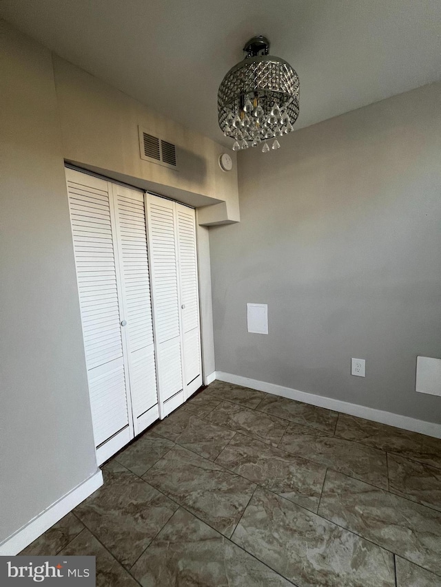 unfurnished bedroom with a notable chandelier