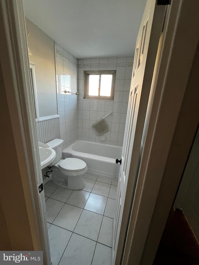 full bathroom featuring sink, tile patterned flooring, tiled shower / bath combo, and toilet