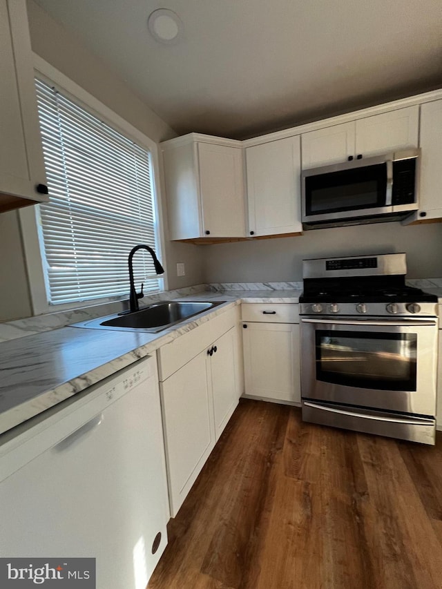 kitchen with white cabinetry, sink, dark wood-type flooring, and appliances with stainless steel finishes