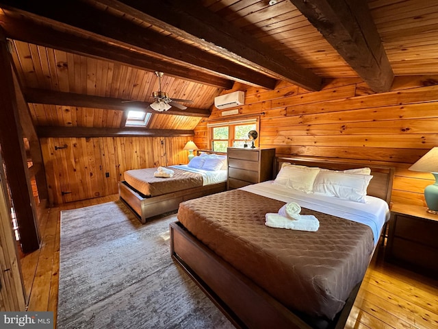 bedroom featuring a wall mounted air conditioner, wood walls, vaulted ceiling with skylight, light wood-type flooring, and wood ceiling