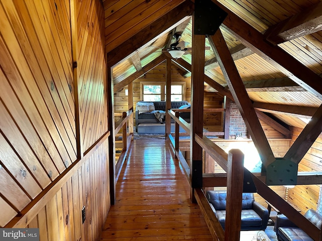 hallway featuring wood walls, wooden ceiling, lofted ceiling with beams, and wood-type flooring