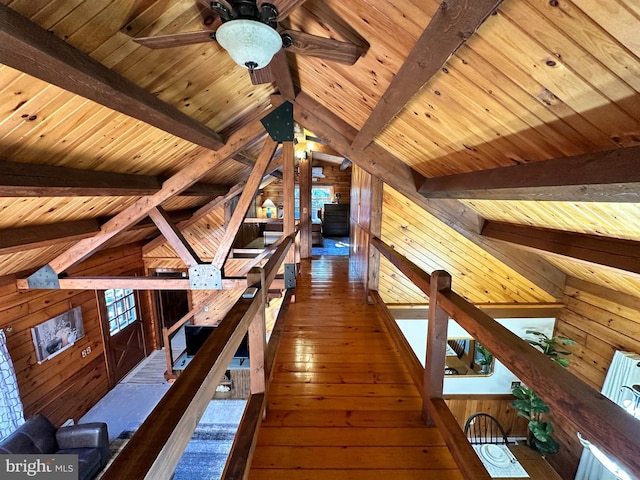 hallway featuring vaulted ceiling with beams, wooden walls, and dark hardwood / wood-style flooring