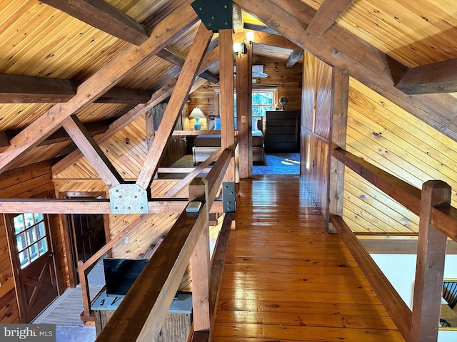 corridor featuring lofted ceiling with beams, wooden ceiling, and wooden walls