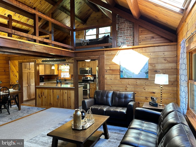 living room featuring wooden walls, carpet flooring, and high vaulted ceiling