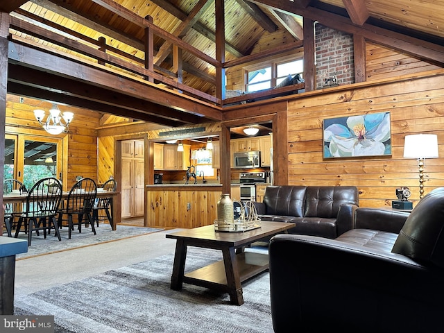 living room featuring carpet flooring, high vaulted ceiling, beamed ceiling, a chandelier, and wood walls