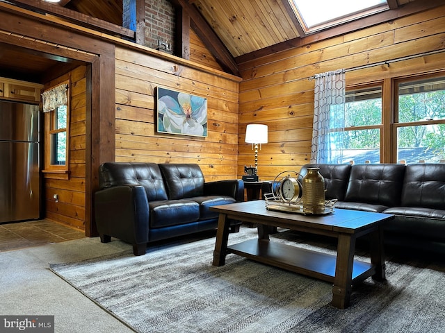 living room with carpet flooring, a skylight, wooden walls, and high vaulted ceiling