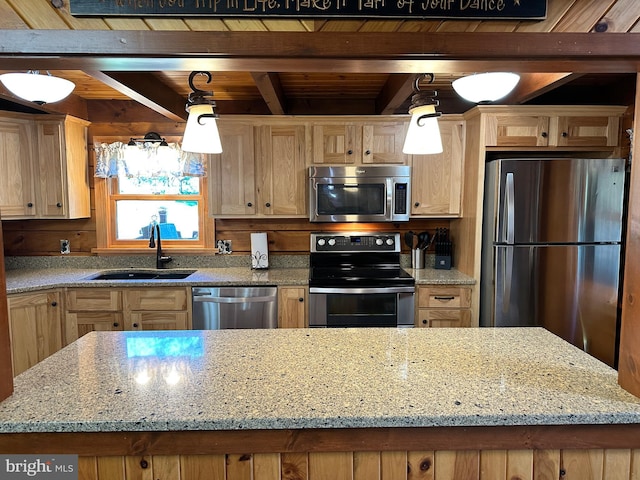 kitchen with appliances with stainless steel finishes, light stone counters, sink, a kitchen island, and hanging light fixtures