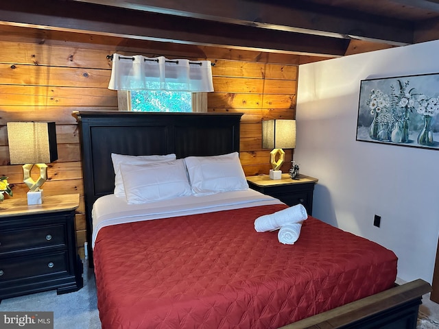 carpeted bedroom featuring wooden walls and beamed ceiling