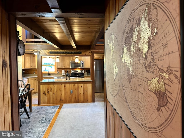 kitchen featuring kitchen peninsula, appliances with stainless steel finishes, wood ceiling, beam ceiling, and wood walls