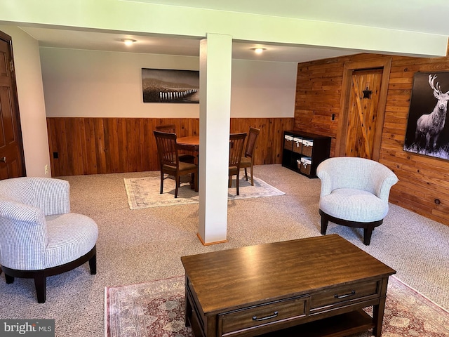 living room with carpet floors and wooden walls