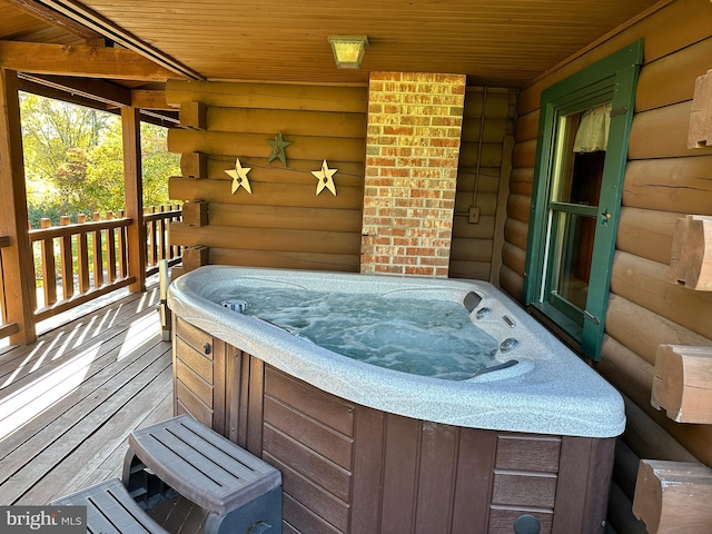 wooden terrace featuring a hot tub