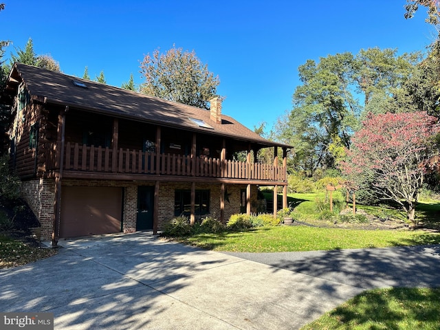 view of front facade featuring a front yard, a balcony, and a garage