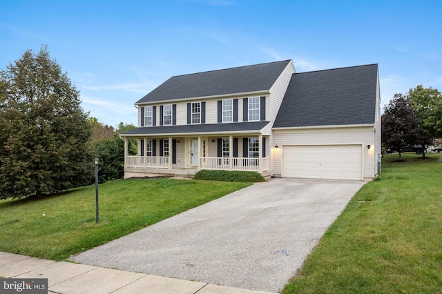 colonial inspired home featuring a porch, a garage, and a front yard