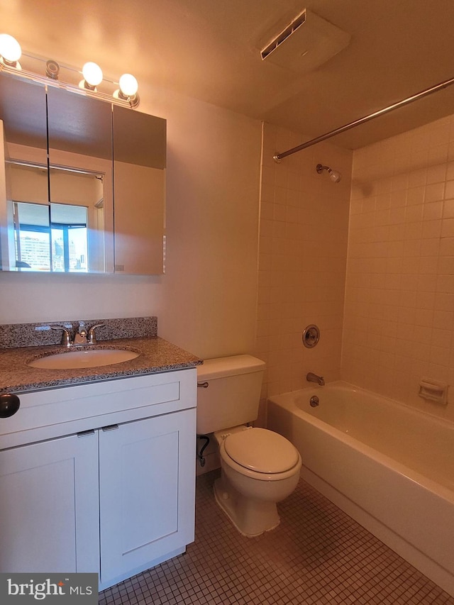 full bathroom with tile patterned flooring, vanity, tiled shower / bath combo, and toilet