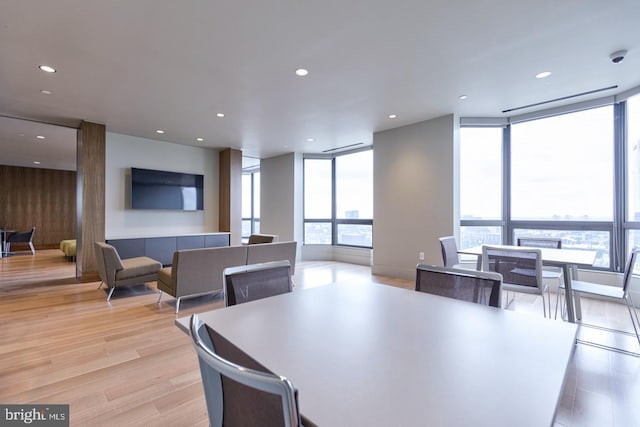 dining room with a wealth of natural light, expansive windows, and light wood-type flooring